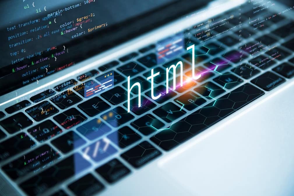 Laptop keyboard with colorful HTML code holographically emerging from the screen